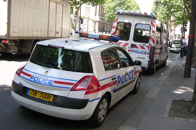 Police car and van parked on a city street
