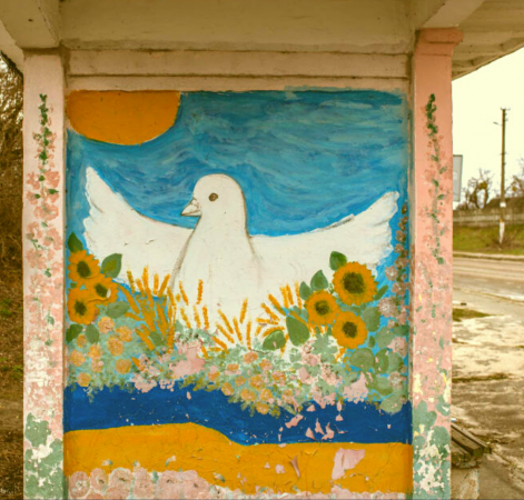 Graffiti portraying a dove and field of sunflowers with the Ukrainian flag