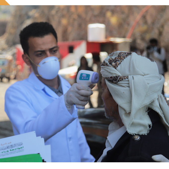 Man wearing a surgical mask and gloves uses an electronic thermometer to take a civilian's temperature reading