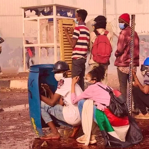 Sudanese citizens shelter behind makeshift shields during a protest in Khartoum, 2022.