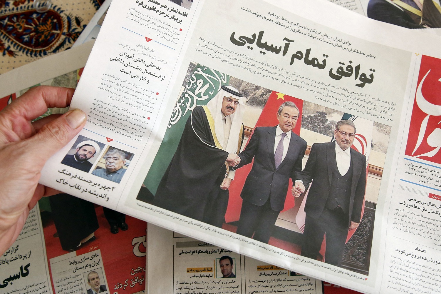 A man in Tehran holds a local newspaper reporting on its front page the China-brokered deal between Iran and Saudi Arabia to restore ties, signed in Beijing the previous day, on March, 11 2023. Photo by Atta Kenare/AFP/Getty Images