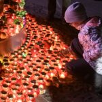 Child at a monument decorated with candles during a commemoration ceremony in Kyiv, Ukraine in 2019. (Photo by Maxym Marusenko/NurPhoto via Getty Images)