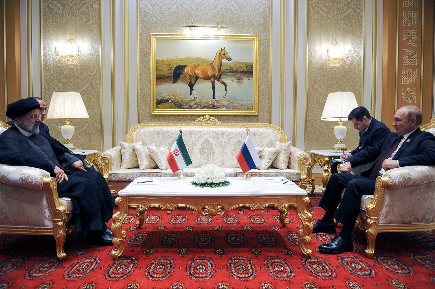 Russian President Vladimir Putin speaks with Iran's President Ebrahim Raisi during their meeting at the 6th Caspian Summit in Ashgabat, June 2022. Photo by MIKHAIL KLIMENTYEV/SPUTNIK/AFP via Getty Images