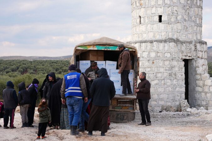 Syrians displaced by the earthquake receive aid at a temporary camp in the village of al-Hamam in the countryside of Jindayris, northwest Syria (February 2023).