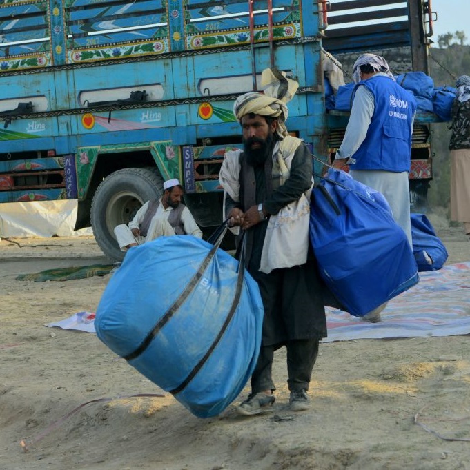 Volunteers carry aid provided by the International Organization for Migration for recent earthquake-affected people in the Afghan-Dubai village of Spera in Khost province, supervised by armed Afghan Taliban (June 2022)