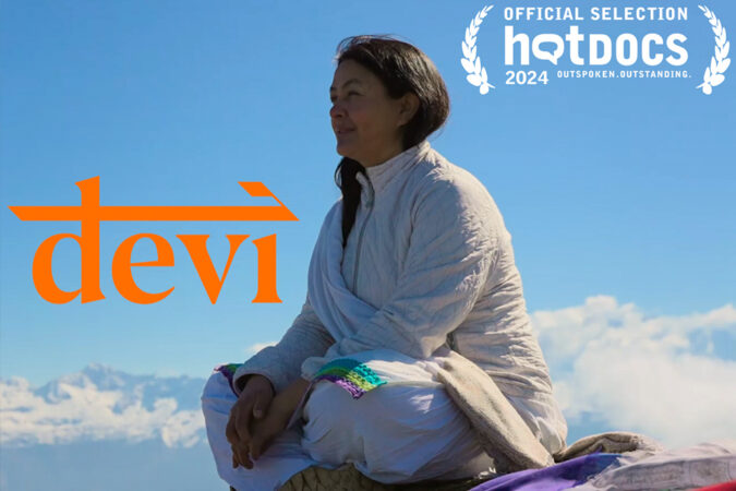 Devi film poster showing a woman sitting cross-legged against a blue sky