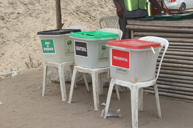 Three ballot boxes balanced on chairs