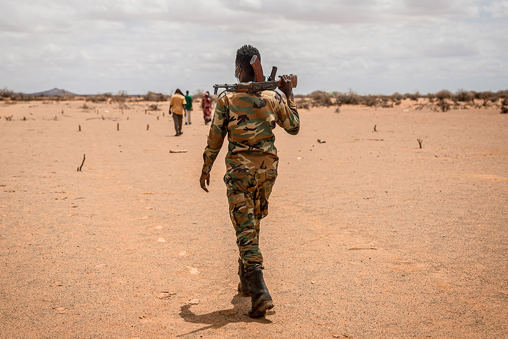 A soldier walks through the desert on the outskirts of Dollow
