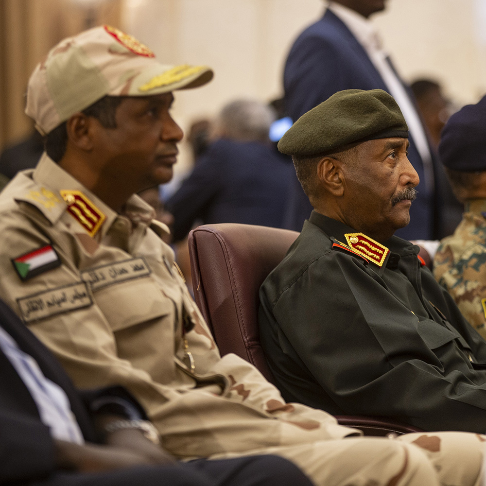 Abdel Fattah al-Burhan (C) and his Deputy Mohamed Hamdan Dagalo (L) attend the ceremony held at the Friendship Congress and Meeting Hall in Khartoum, Sudan