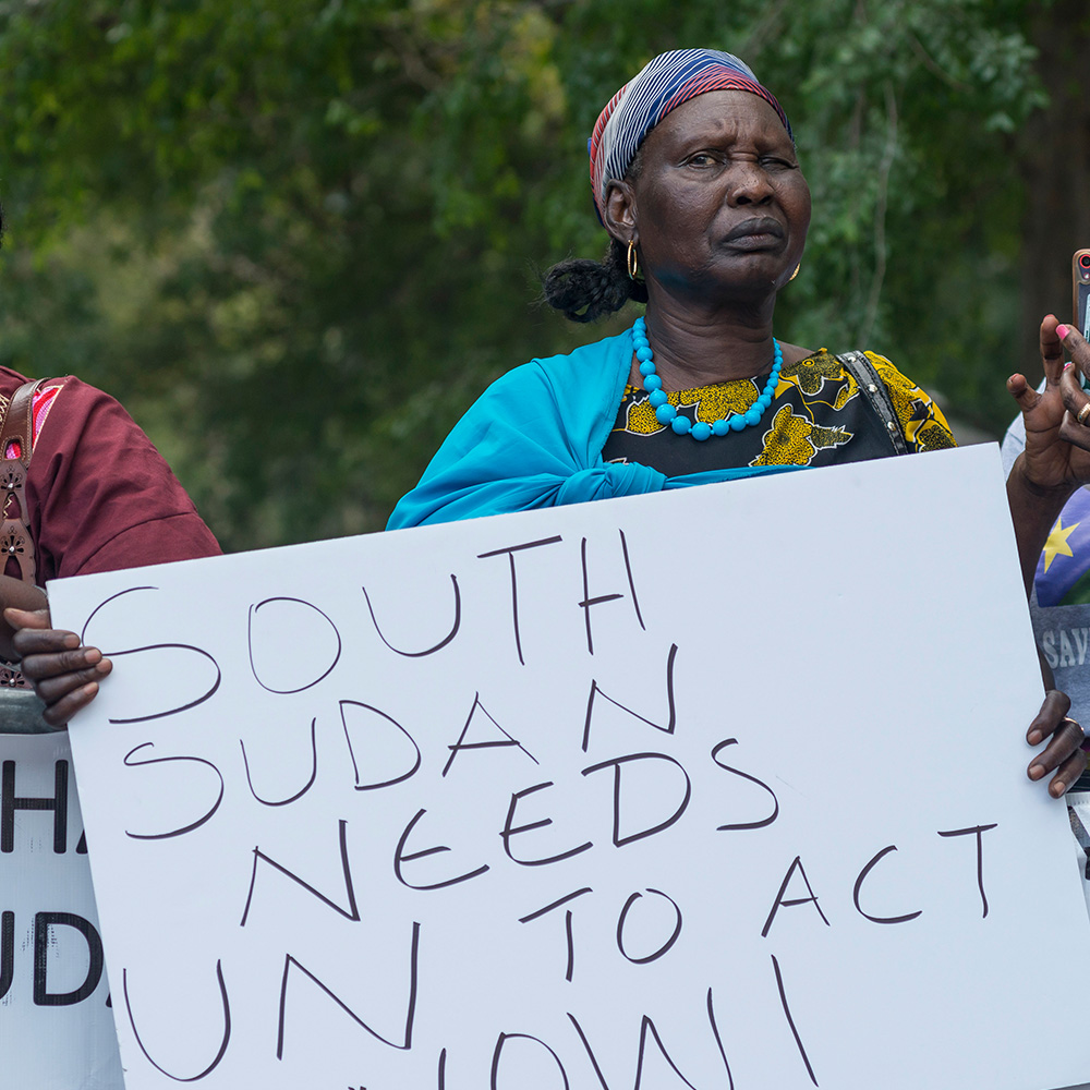 South Sudanese demonstrators hold signs urging the UN to act