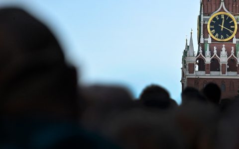 A crowd of people in front of a clock in Moscow
