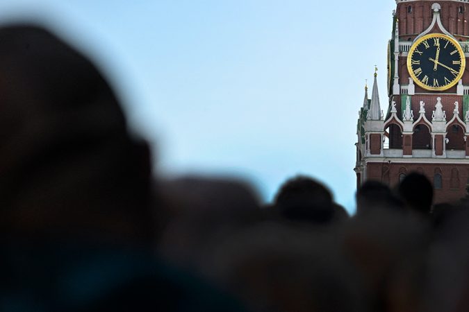 A crowd of people in front of a clock in Moscow
