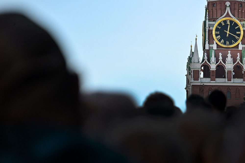 A crowd of people in front of a clock in Moscow