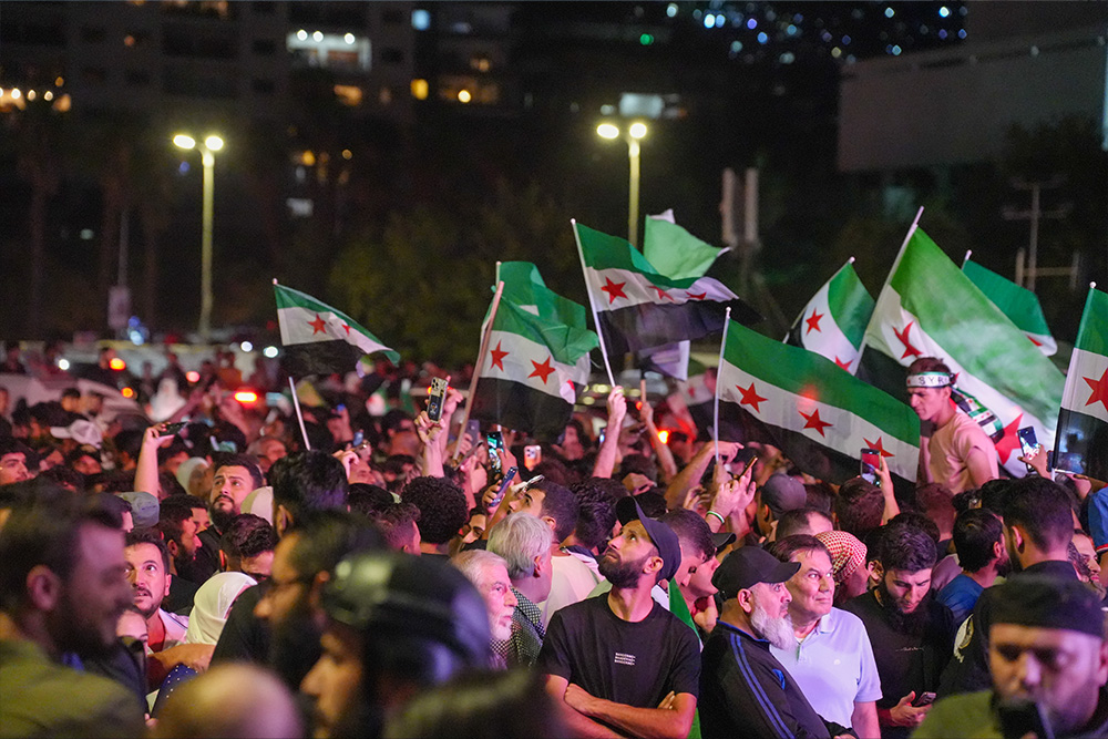 A crowd of Syrians gather with flags
