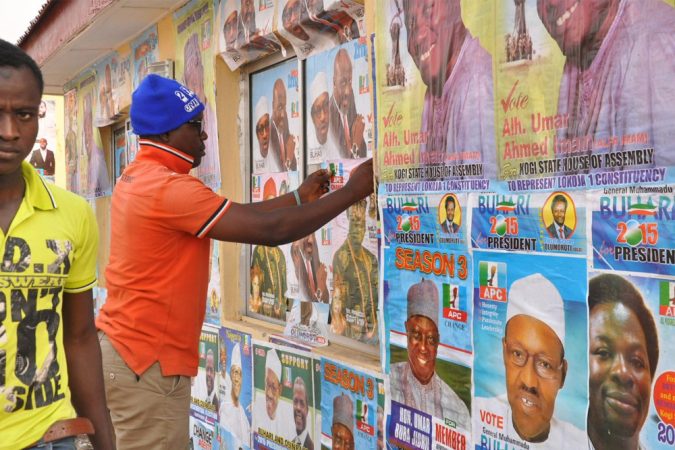 A man sticks a poster on a wall