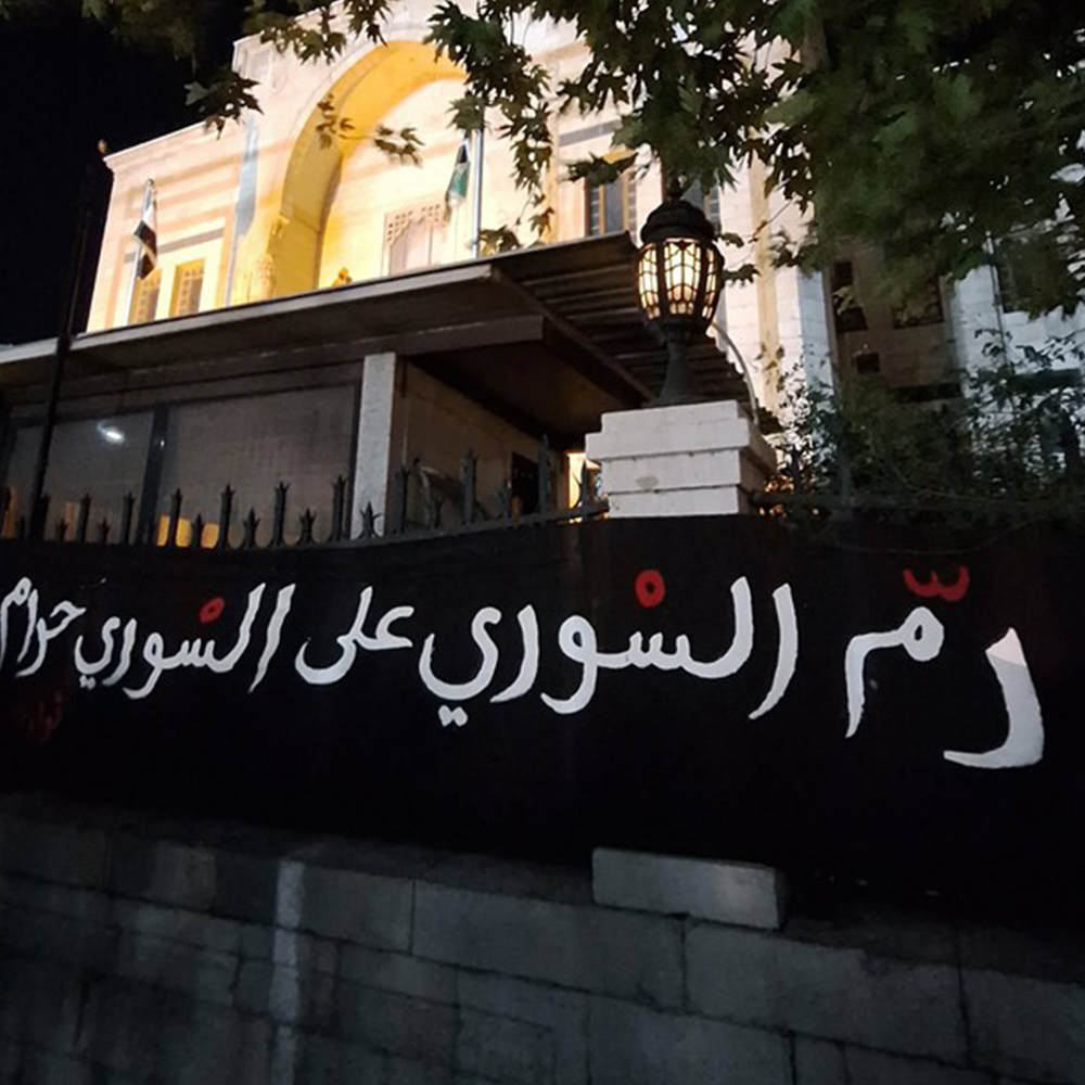 A banner installed by civic activists at the gates of the Syrian People’s Assembly after the attacks in Suwayda. The banner reads: “The blood of one Syrian is forbidden to another”.