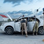 Officers search a car at a checkpoint in Mogadishu