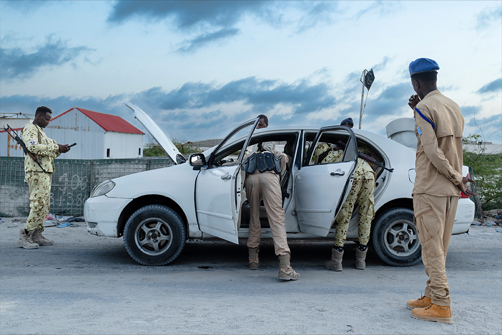 Officers search a car at a checkpoint in Mogadishu